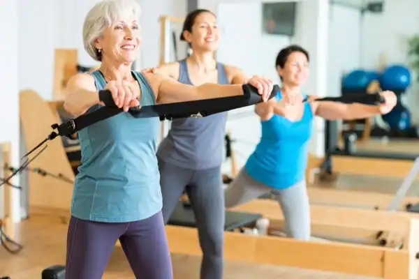 Toning Arms After 60: Empowering Womens Fitness Through Effective Weight Training 2 older woman doing weight training Teddington and resistance in the gym to tone upper arms